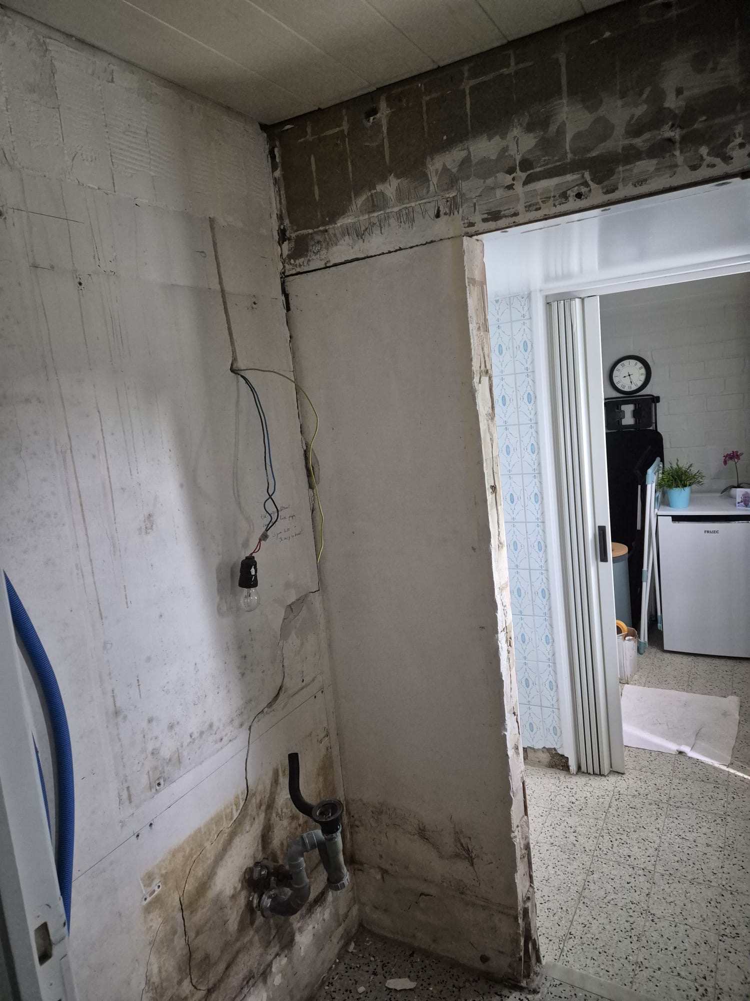 Verbrede muuropening in dragend metselwerk met nieuw stalen stijlwerk tijdens het strippen van een badkamer